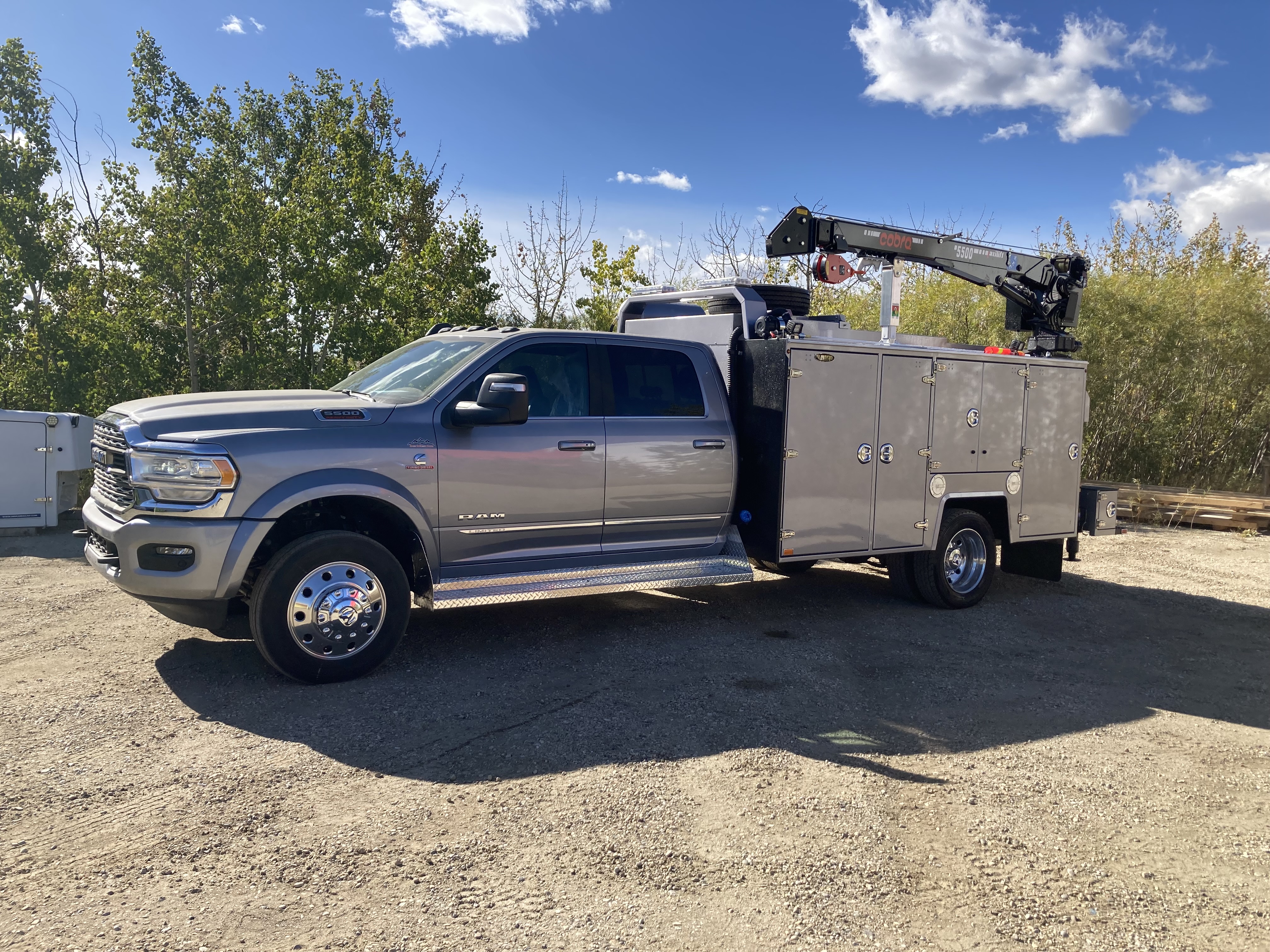 Silver Brutus service body truck with crane and compartment storage