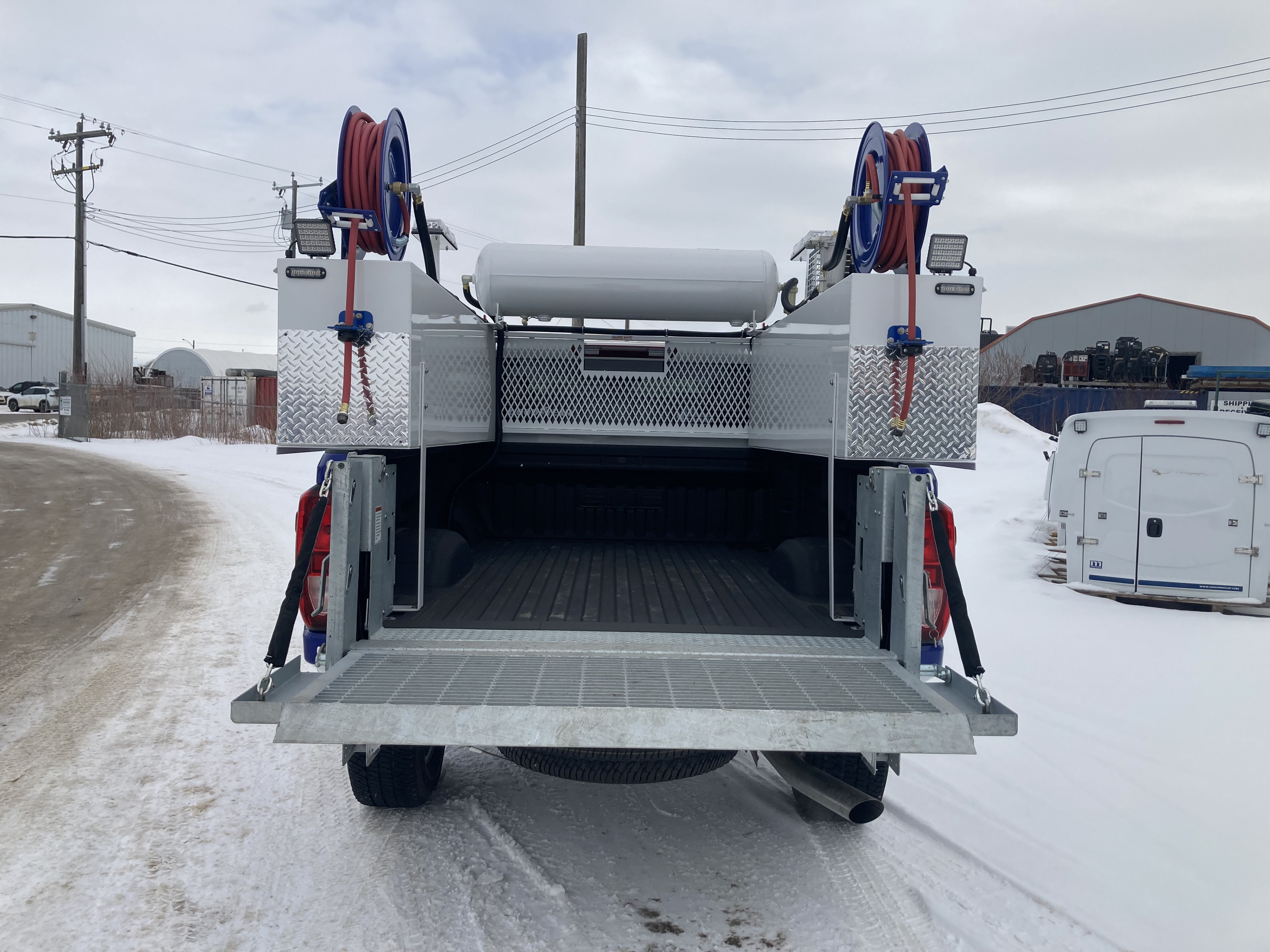 Rear view of TK tire service truck body with hose reels and work platform