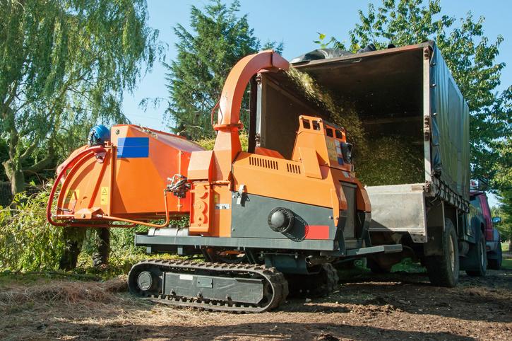 Wood chipping operation within chipper truck